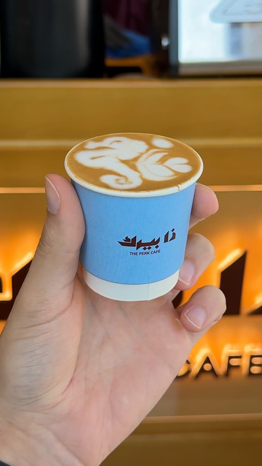 Cortado under the Perk neon sign